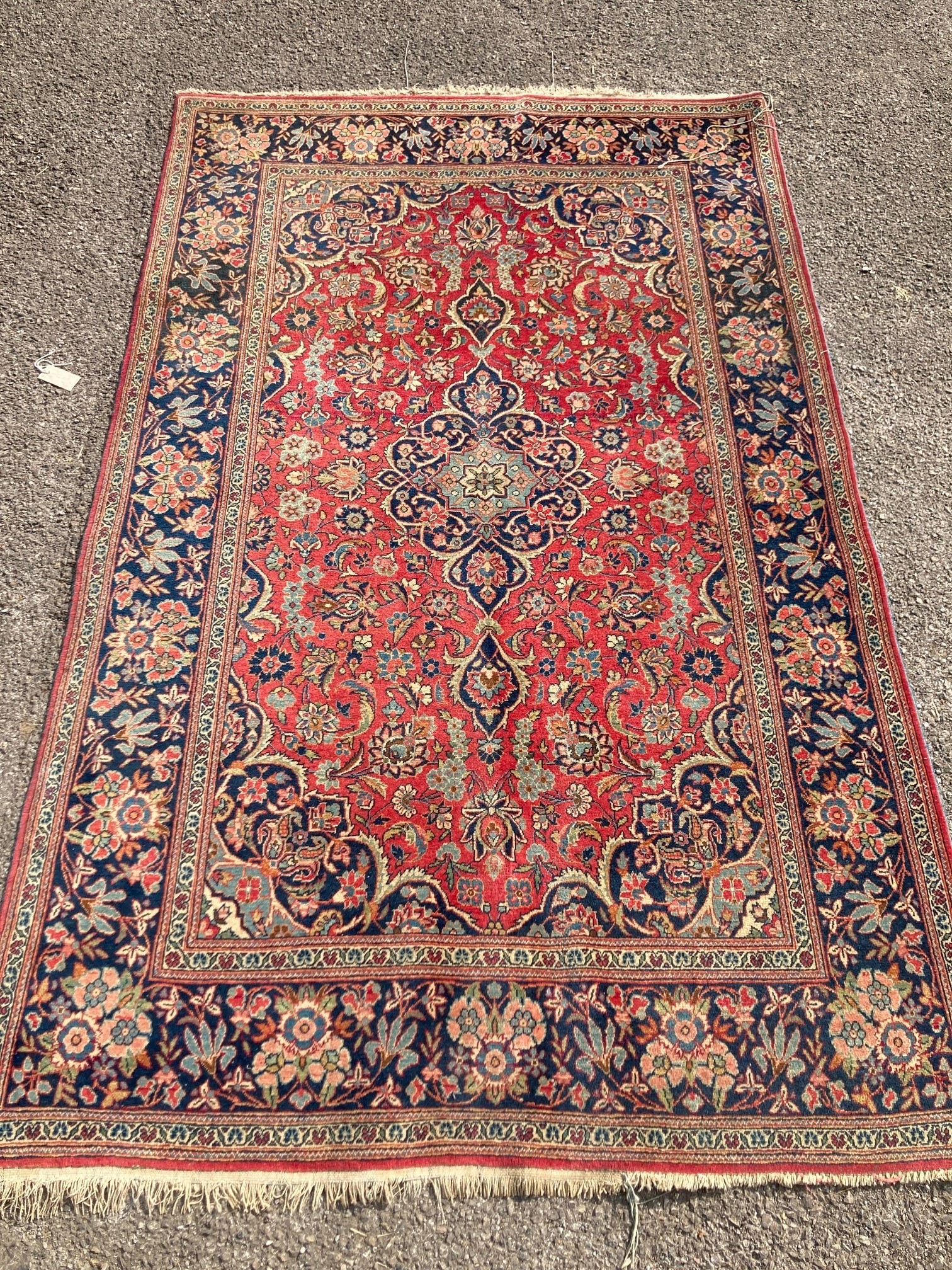 A Kashan red ground rug, with all-over stylised floral motifs